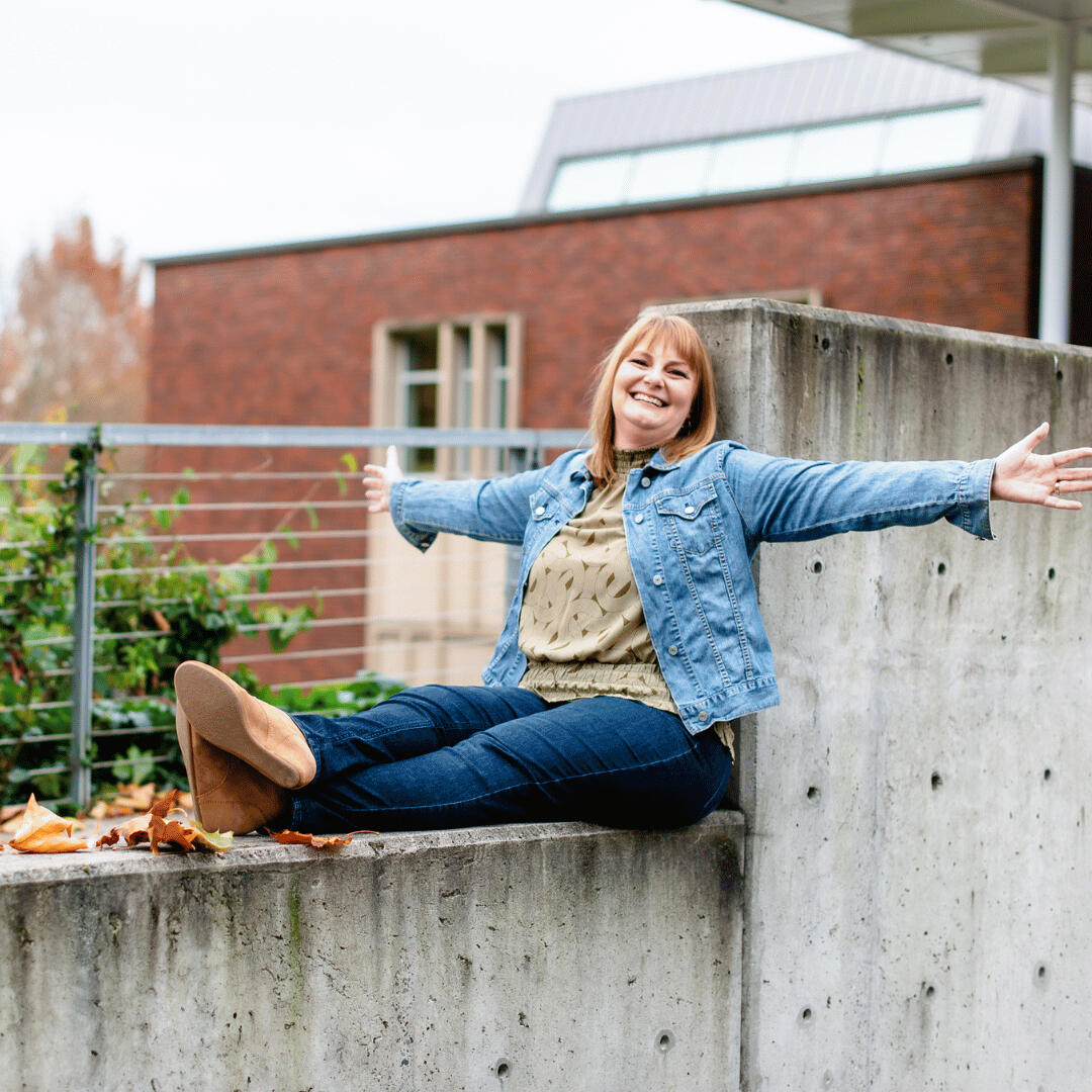 Renew Therapy NW Jennifer Jim Licensed Professional Counselor Jennifer Jim is sitting on a wall with her arms outstretched. Renew Therapy NW